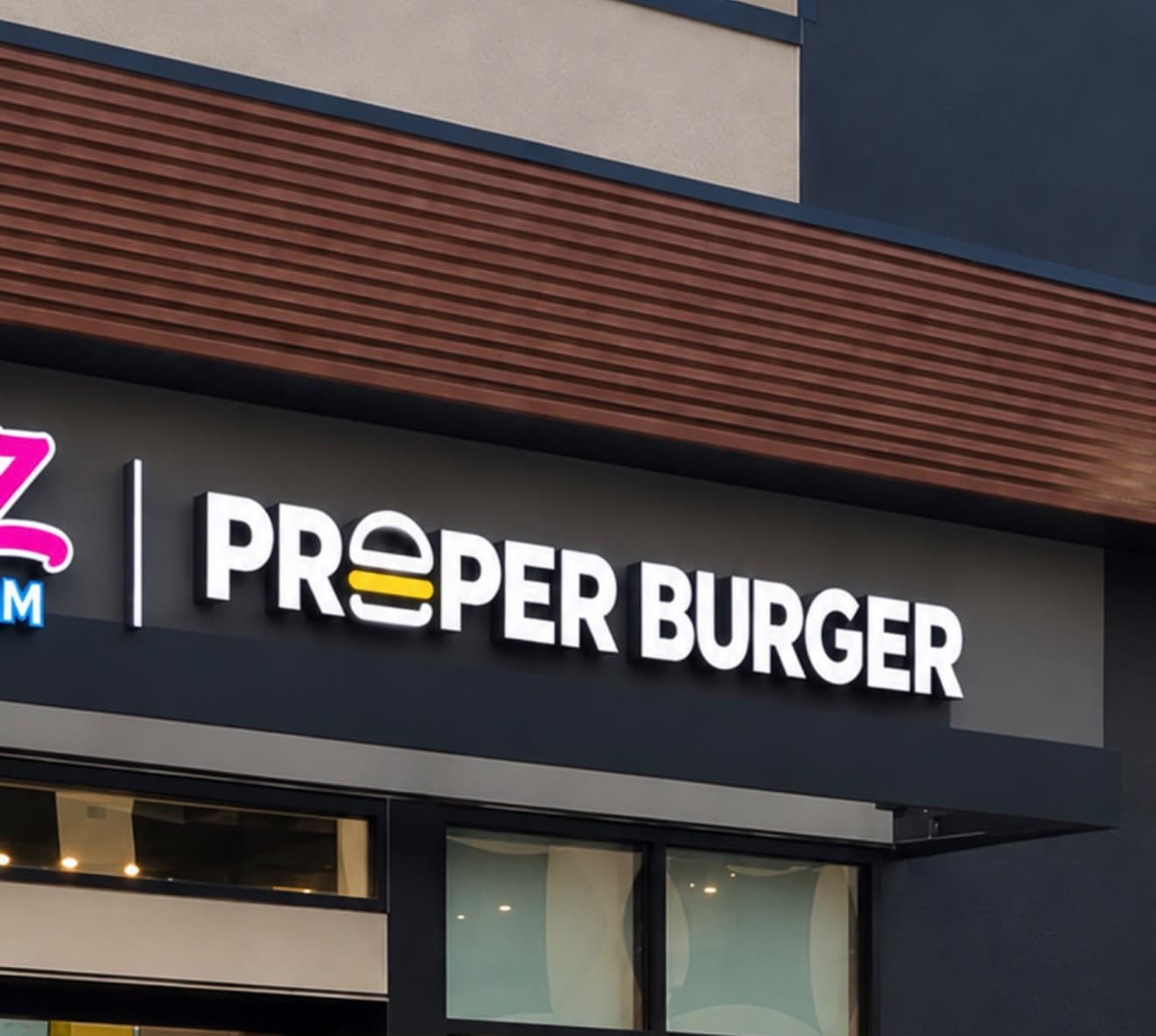Proper Burger storefront beside Rollz Ice Cream and Desserts in Sage Hill.